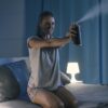 Angry woman spaying insectide in her bedroom